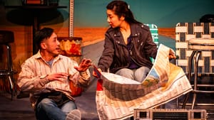 Next to a vintage boombox, Ngo spreads a map and looks worriedly at Tan sitting beside her, talking happily.