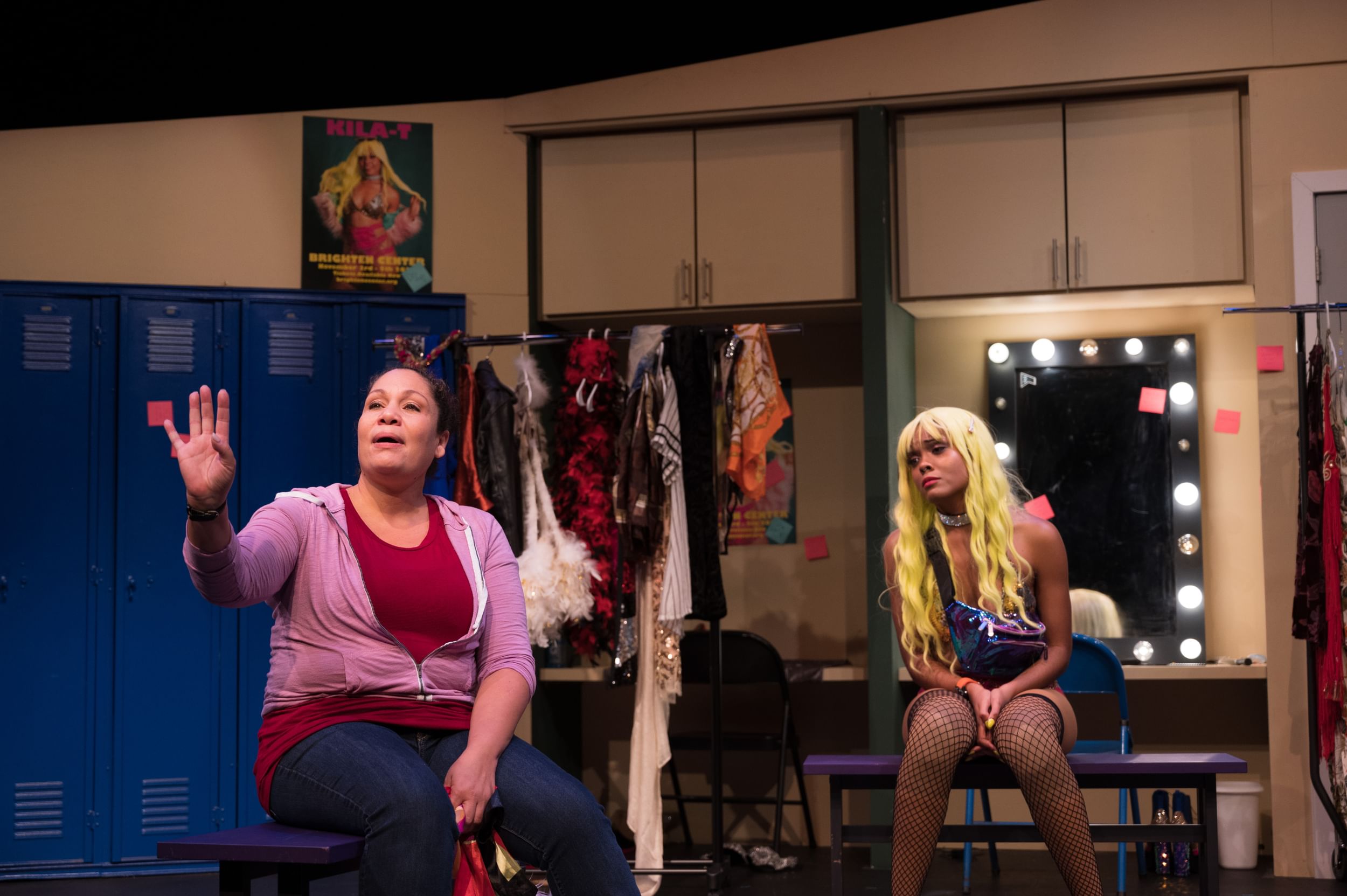 A scene from the play. Tolentino wears a red shirt & purple hoodie; Bey fishnets and long blond hair. They both look wistful