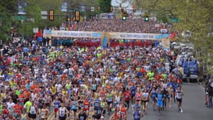 A mass of people filling a city street, with the banner Blue Cross Broad Street Run overhead.