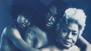 3 Black people hold each other, in a line, looking to viewer. Image blends photo with cyanotype, making vivid blue & white