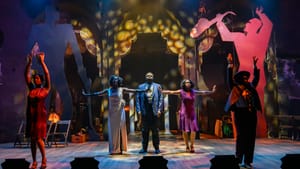 Five cast members in 1920s formal wear pose together, on an Art Deco stage with giant human silhouettes behind.