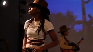 Lee in profile in front, wearing a cowboy hat and placing their hands on their belt; Rise in the background, playing a guitar