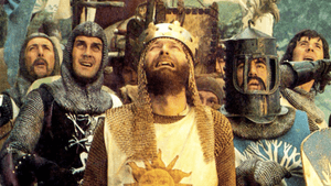 The camera captures a group of men in medieval armor yelling in unison, looking on with concern.